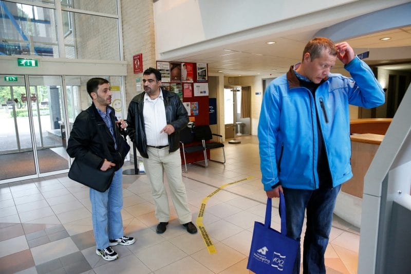 Aiman gaat samen met zijn zwager en een vrijwilliger van Vluchtelingenwerk naar het gemeentehuis in Sassenheim om zich in te schrijven bij de gemeente, 2 juni 2015.